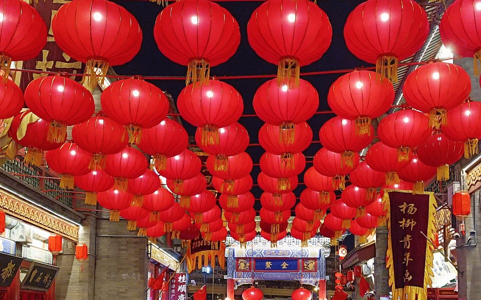 Red lanterns fill the night sky above Tianjin Ancient Culture Street's shops and archway
