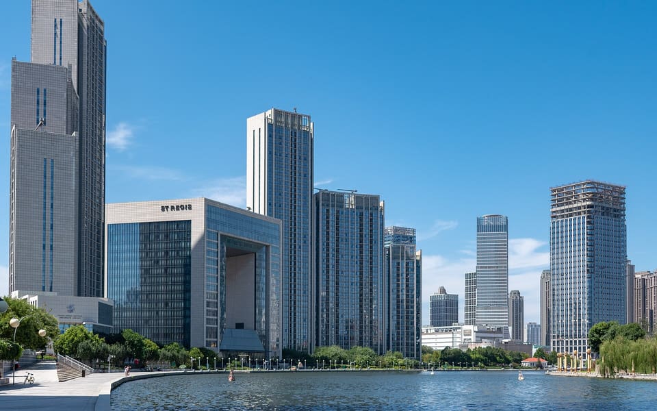 The Hai River curves past Heping District's modern waterfront towers under a clear blue sky