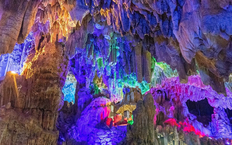 Colorfully illuminated stalactites and limestone formations inside Reed Flute Cave in Guilin