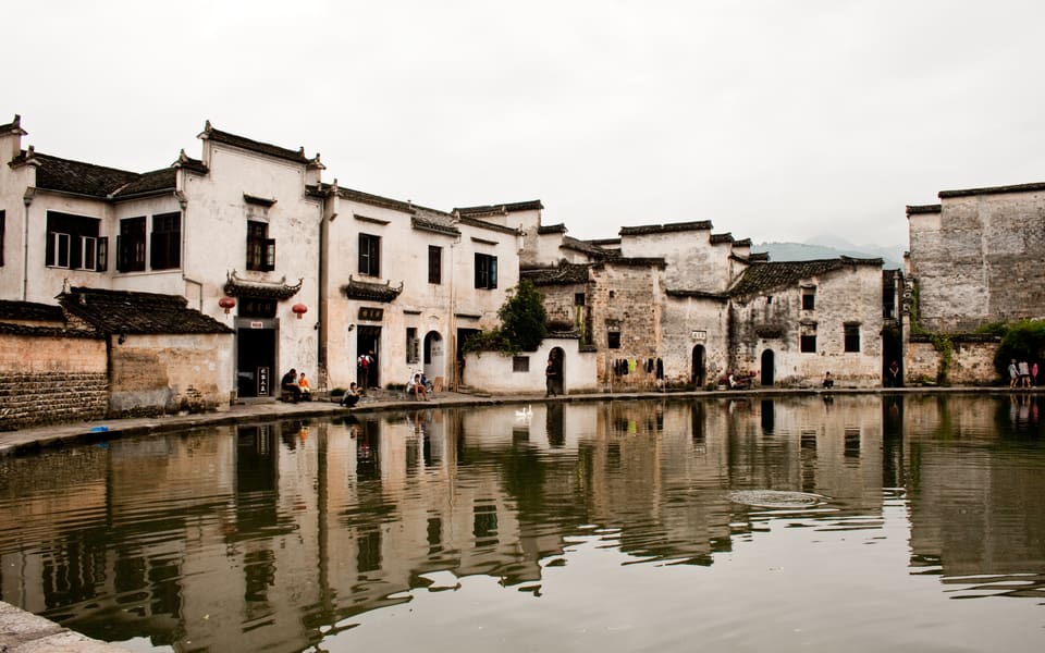 White-walled Huizhou houses reflected in a pond at Hongcun village