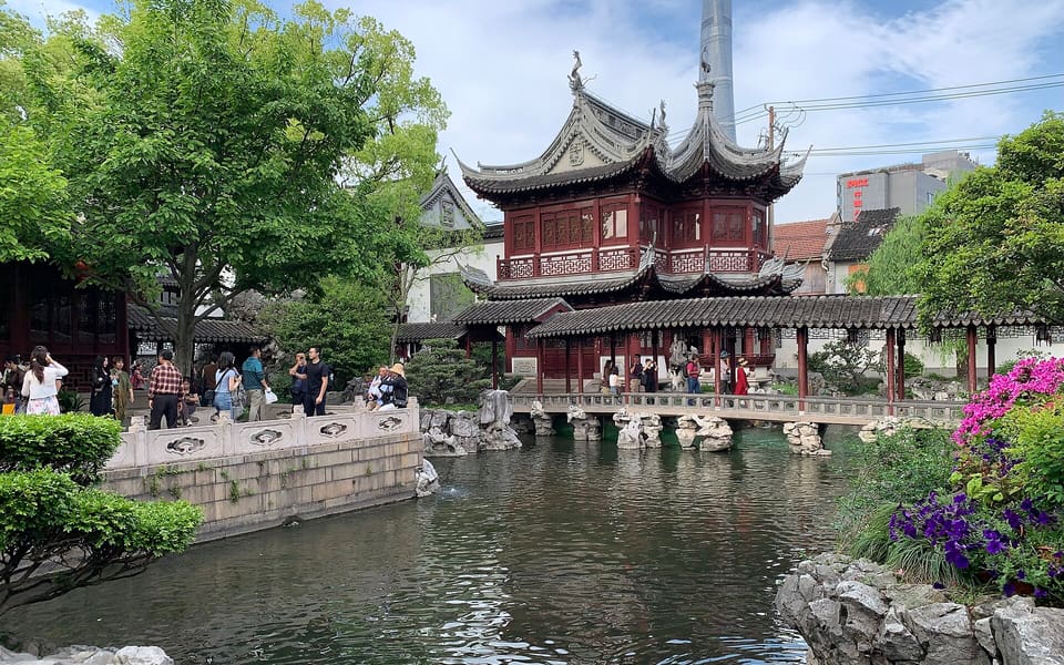 A red traditional pavilion, pond and rock garden inside Shanghai's Yuyuan Garden