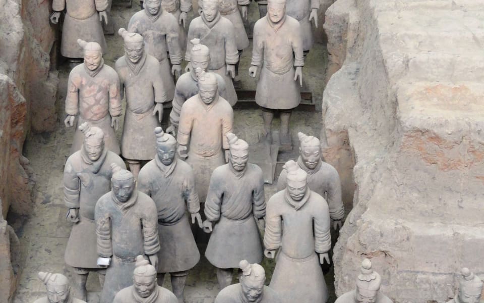 Rows of life-sized terracotta warriors standing in an excavated pit at Emperor Qinshihuang's Mausoleum Site Museum