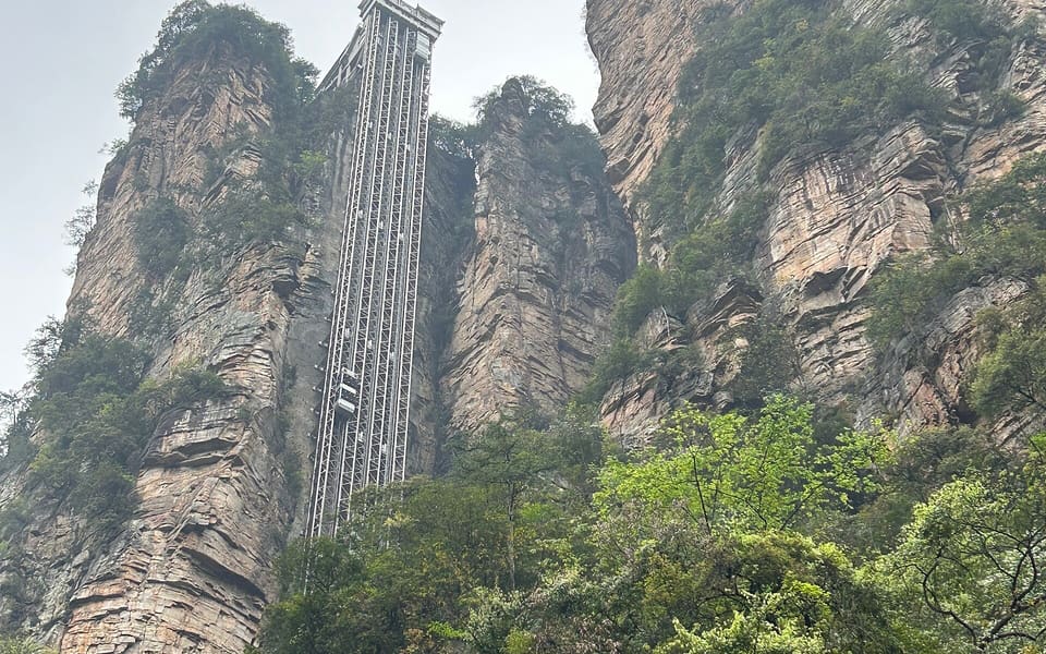 Bailong Elevator rising between forested sandstone cliffs in Zhangjiajie National Forest Park