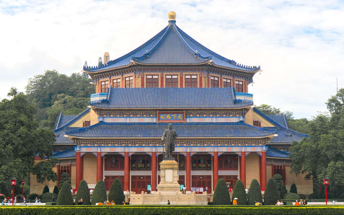 Blue-tiled octagonal Sun Yat-sen Memorial Hall framed by trees and gardens in Guangzhou