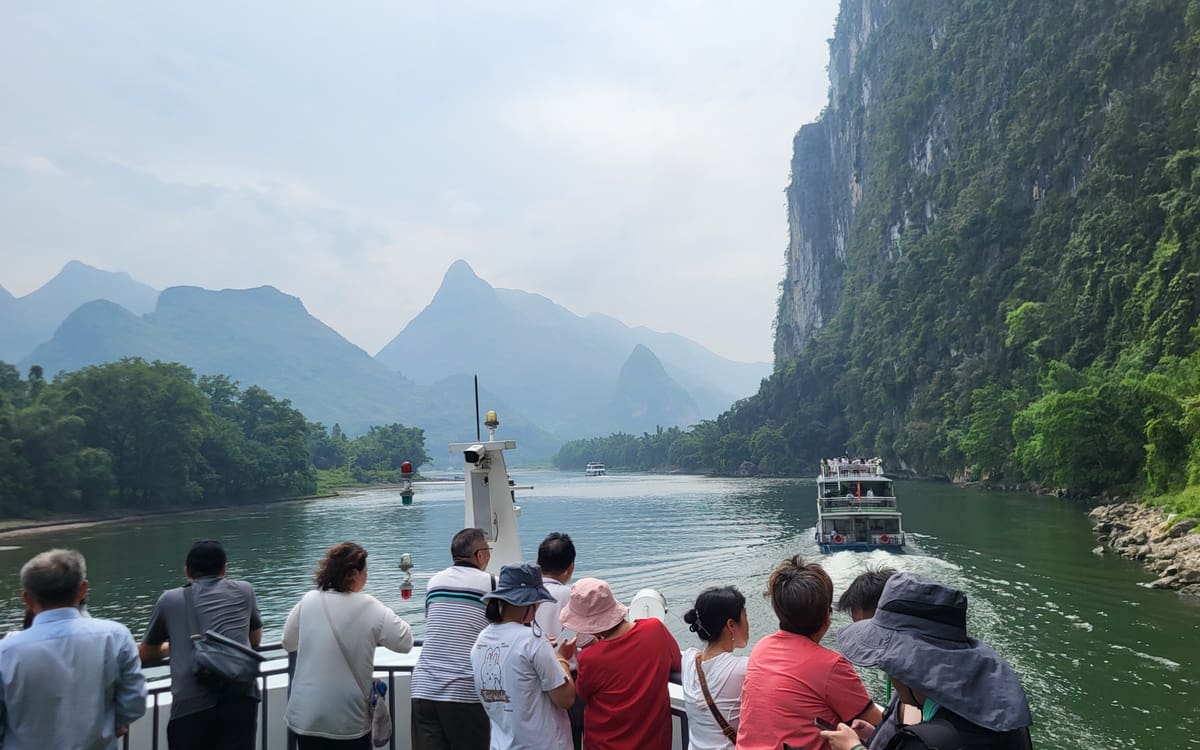 Passengers on a Li River cruise surrounded by limestone karst mountains near Guilin