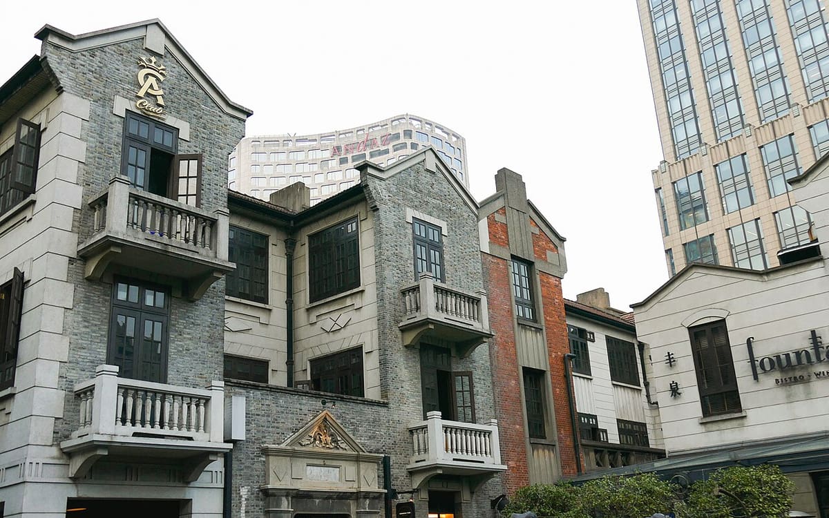 Shikumen-style buildings at Xintiandi with modern towers rising behind them in Shanghai